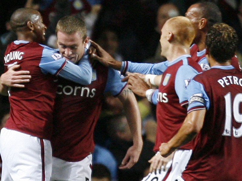 Richard Dunne celebrates with his new Villa team-mates after heading them into a 1-0 lead